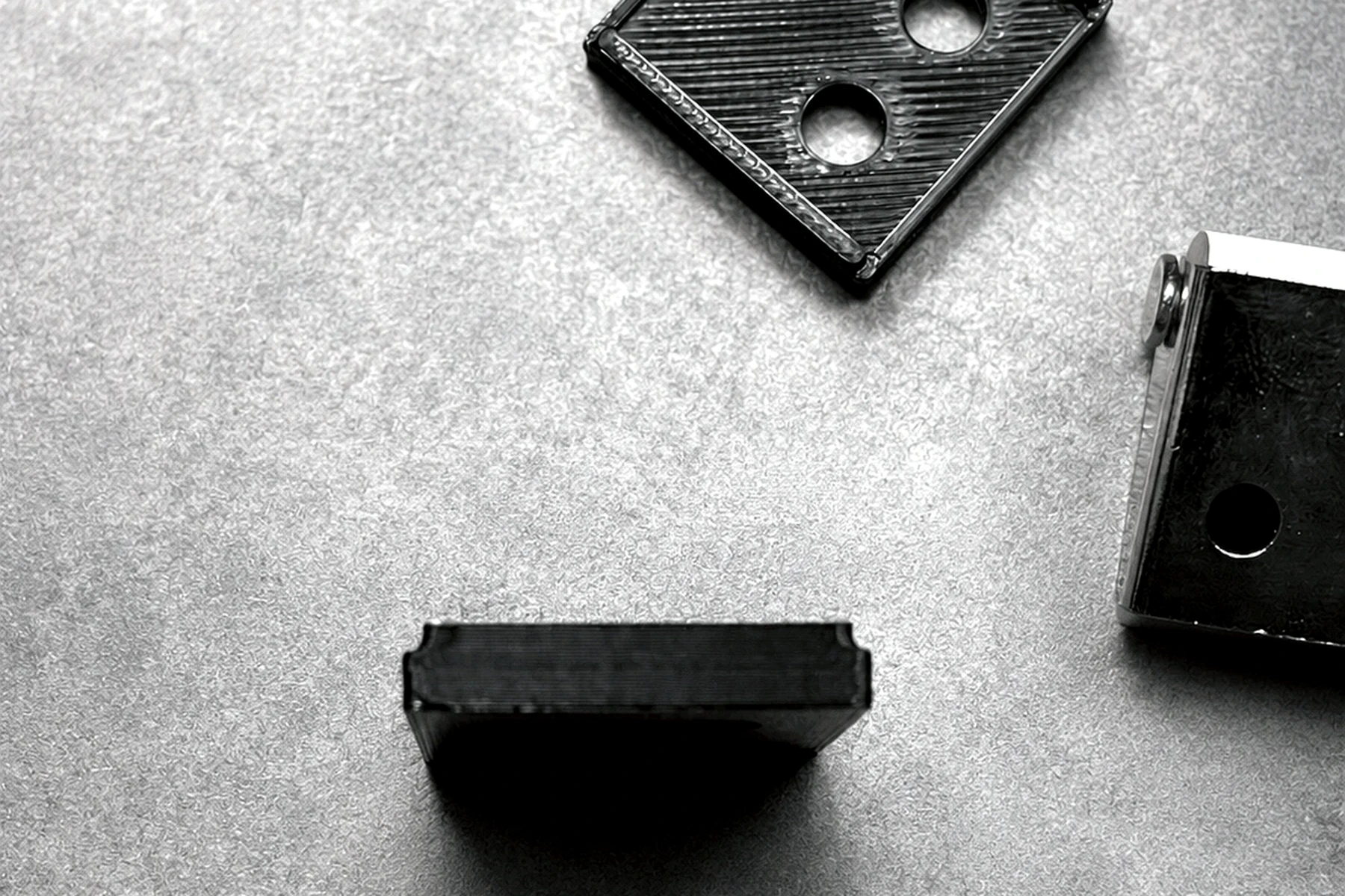 Black custom production brackets made for cabinet manufacturing support.