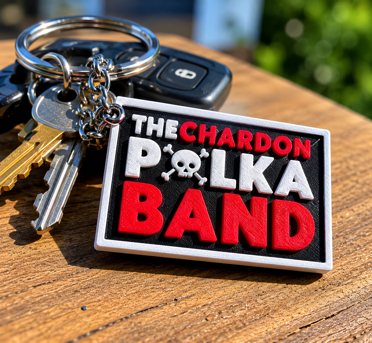 A Chardon Polka Band keychain on a keyring in daylight.