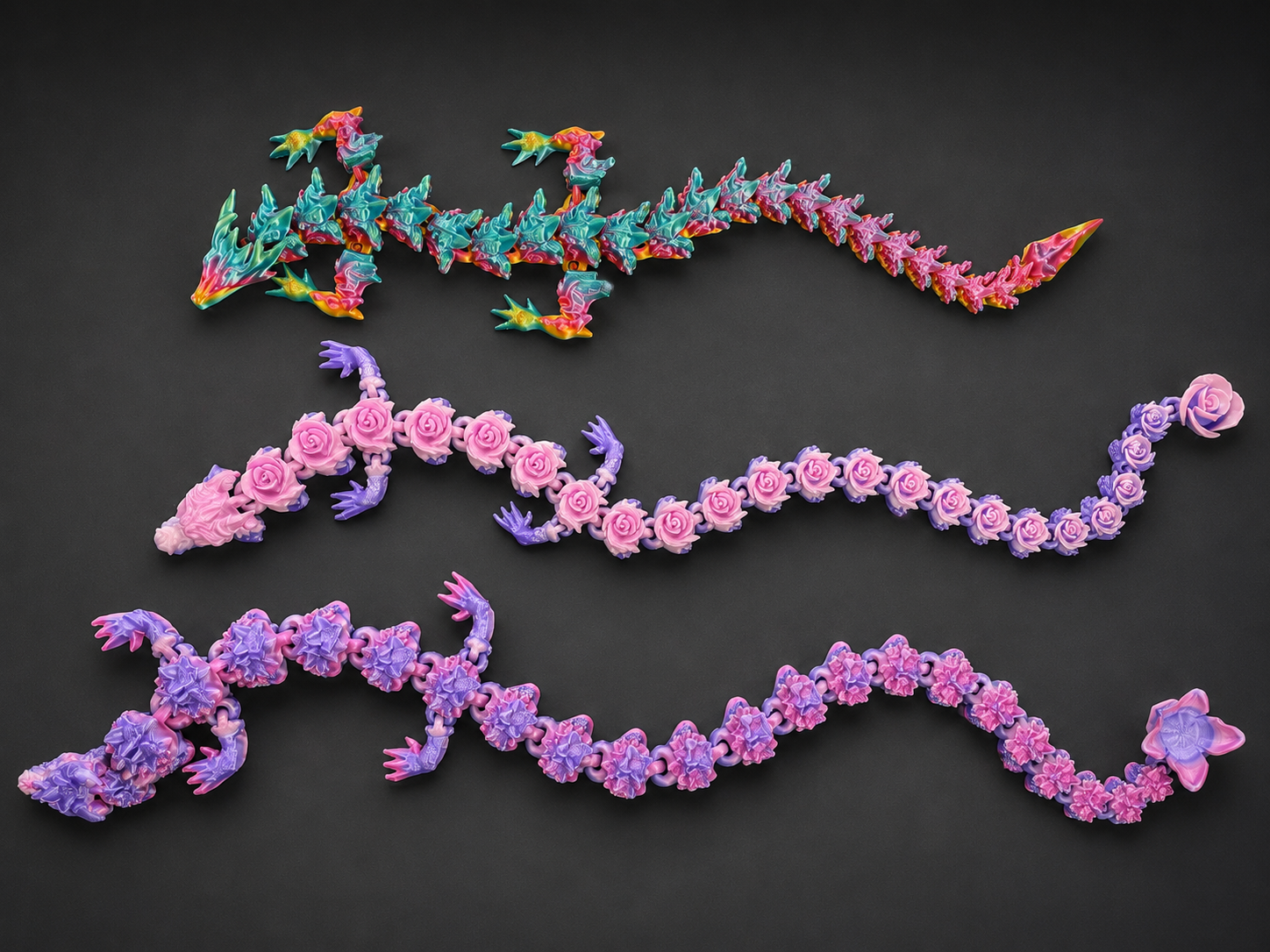 Three colorful articulated dragons arranged on a dark studio background