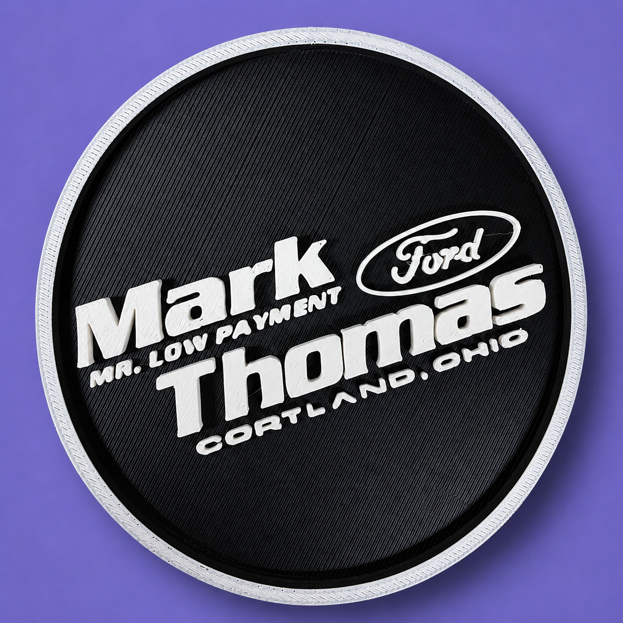 A black and white branded Mark Thomas Ford coaster.